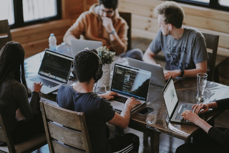 Team arbeitet gemeinsam an Laptops